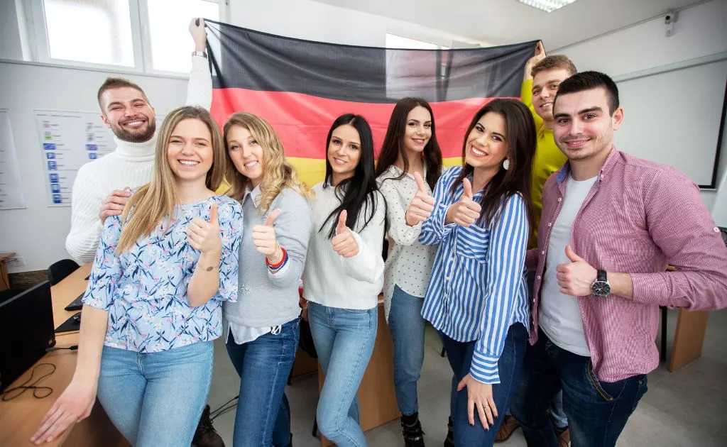 studenti con pollice in su davanti bandiera tedesca